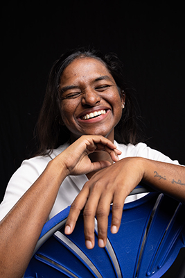 Shaliny laughing and sitting in a blue chair