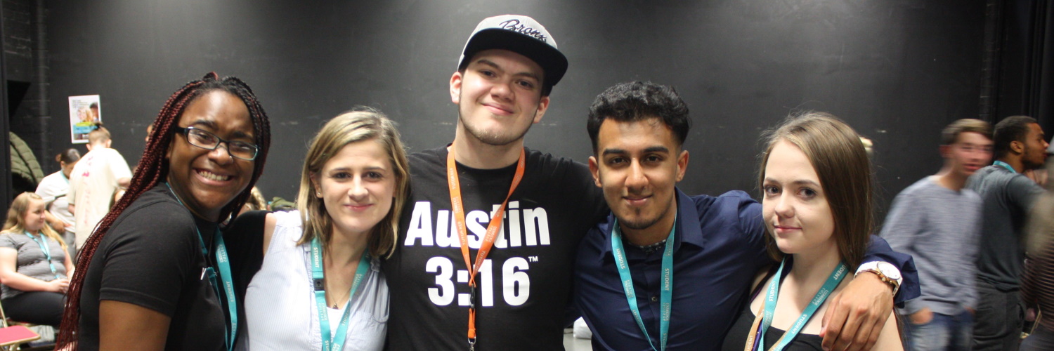 A group of Uxbridge students, with arms around each others shoulders smiling at the camera. 