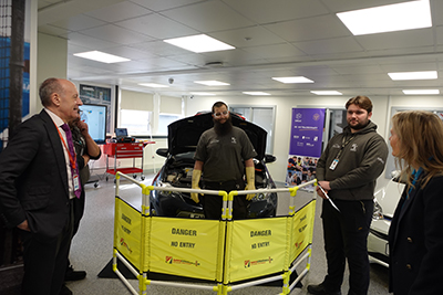 Deputy Mayor Jules Pipe looking at the Uxbridge College facilities and engaging with apprentices working on electric vehicle technology.