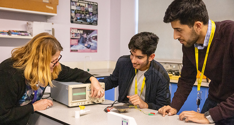 Sixth Form students from Uxbridge College getting taught about Science. Teacher is demonstrating how to use an oscilloscope.