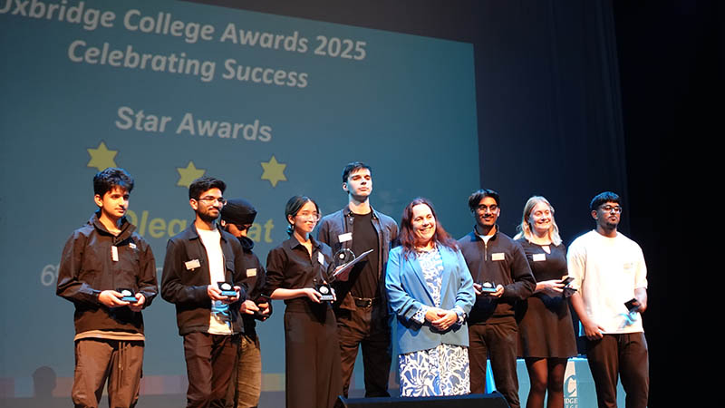 A group of Uxbridge College Students at the Uxbridge Student Awards Ceremony, on stage holding their awards. They are posing for a photo with Jo Salter MBE, Britain’s first female jet pilot.