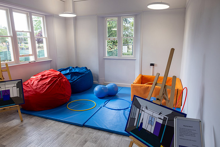 Barra Hall Sensory Room with bean bags, hoops and balls. There are windows either side of the room and the room is white and bright.