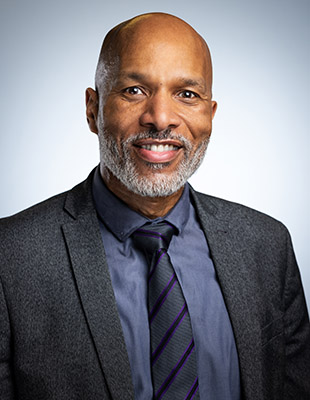 Clive Hodge, new College Principal, Uxbridge College. He is wearing a grey suit jacket, blue shirt and tie.