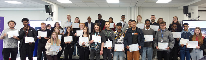Uxbridge College English GCSE students who participated in the Young Writers Stranger Sagas competition posing for a group photo while holding their certificates.